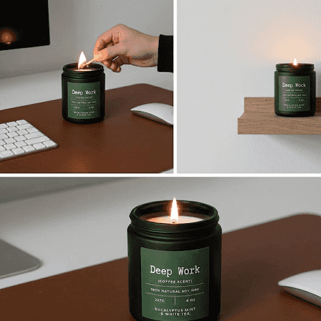 Hand lighting a black Deep Work aromatherapy candle with eucalyptus mint scent at a workspace, promoting concentration and deep work