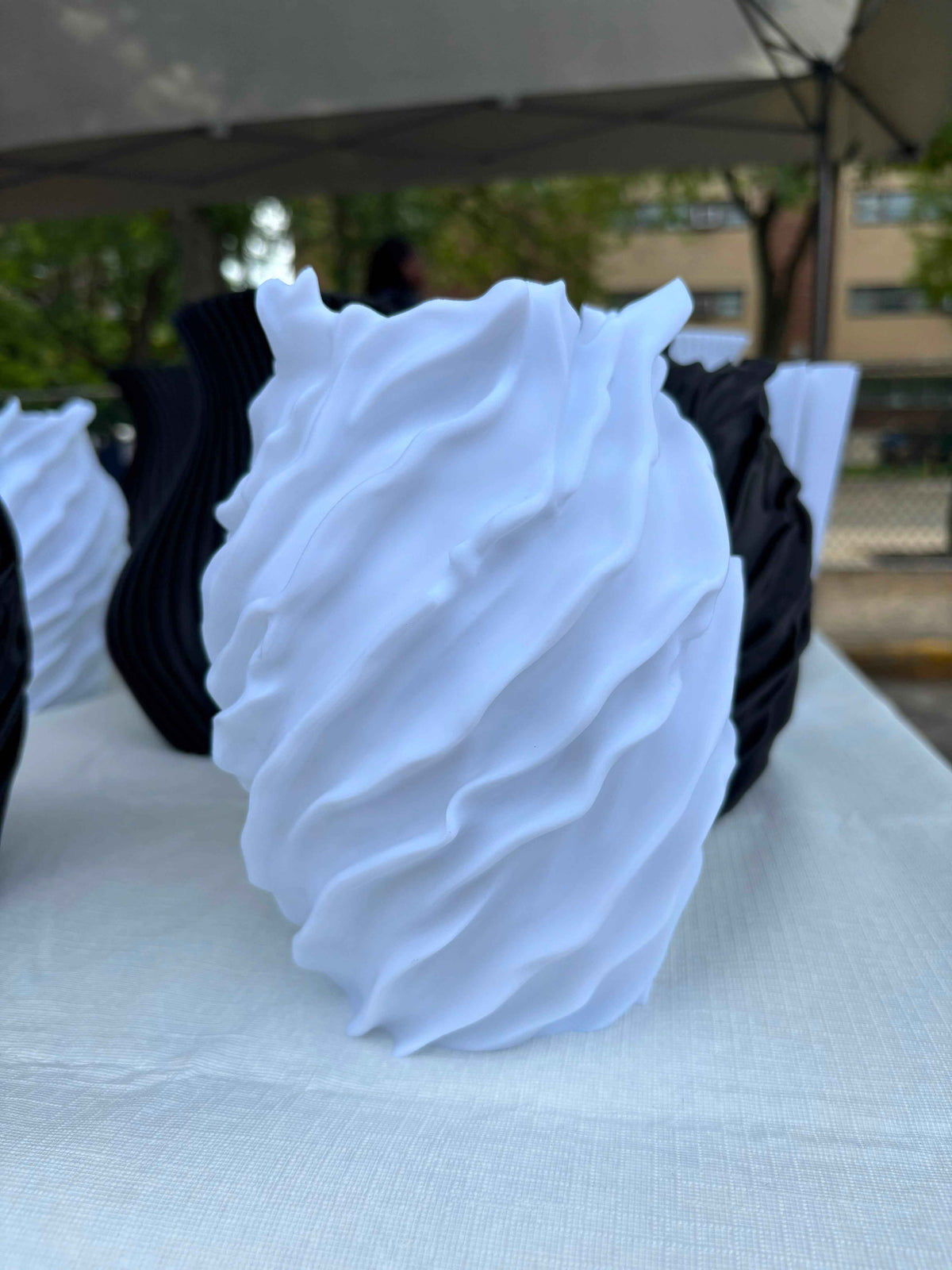 The Flow Vessel in white and black displayed at outdoor market